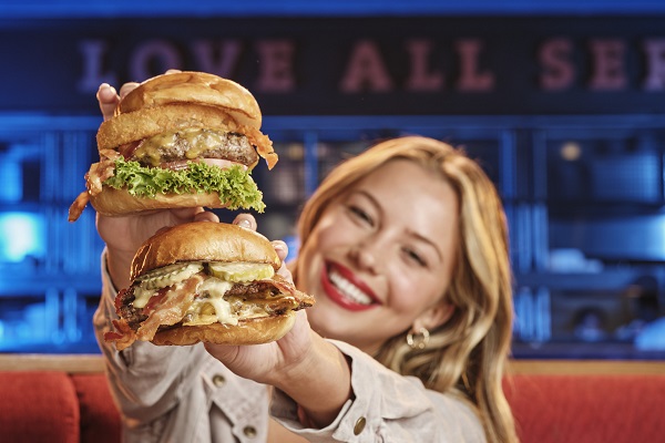 Eine Frau hält zwei Burger hoch