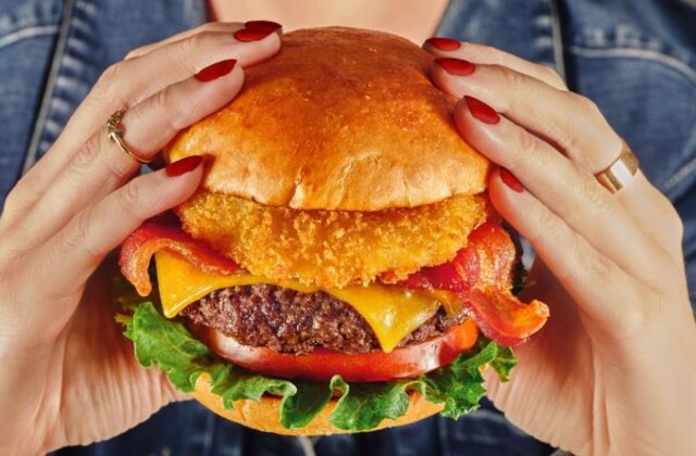 a person holding a burger