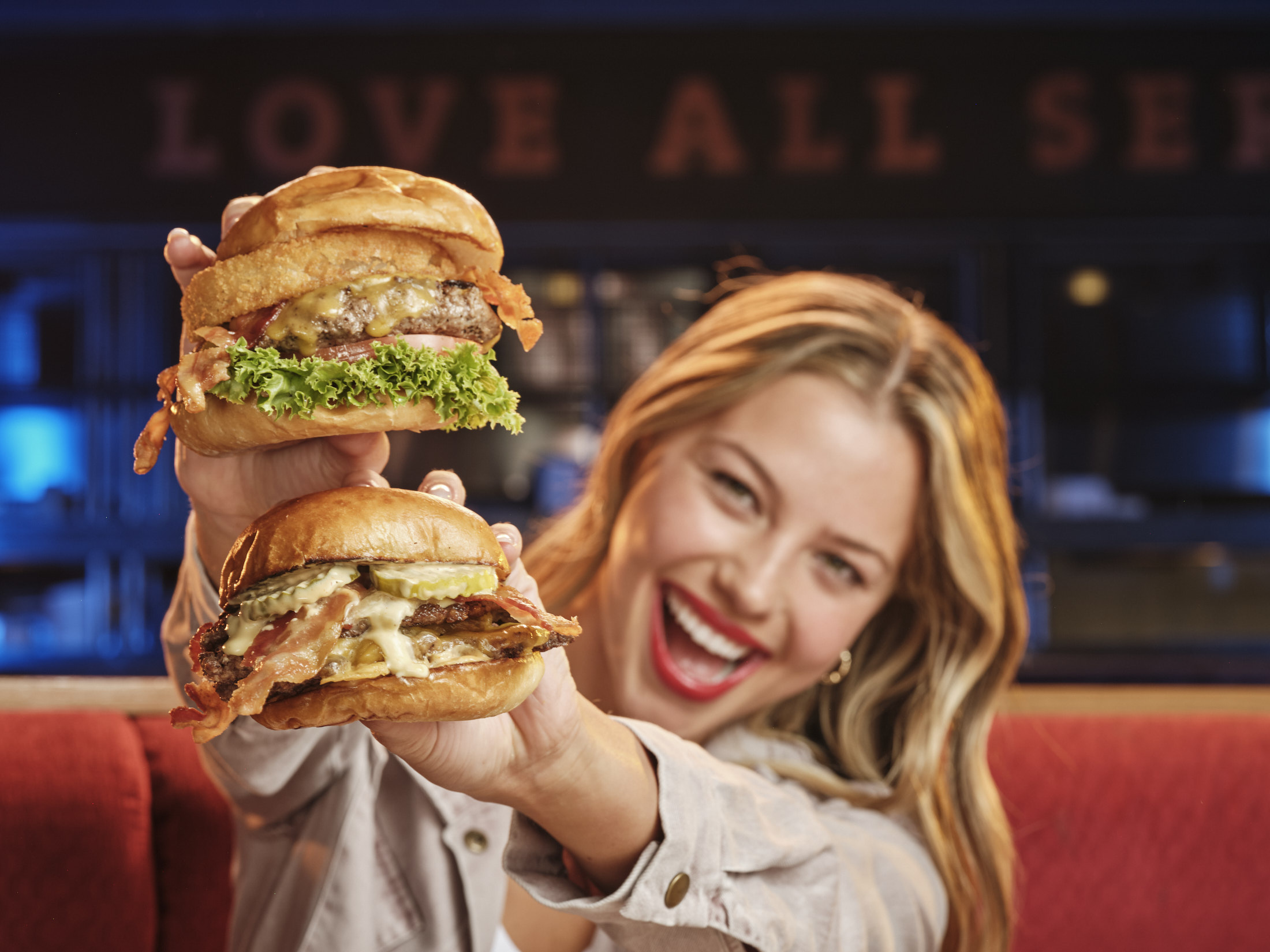 Young woman holding up a burger and chicken sandwich Young woman holding up a burger and chicken sandwich