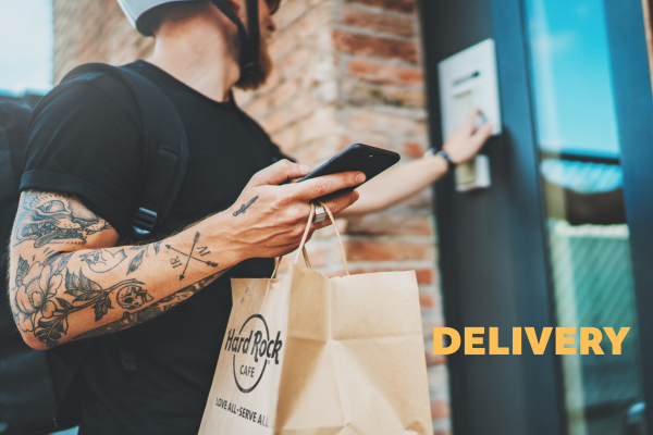 a man with a beard holding a phone and a bag