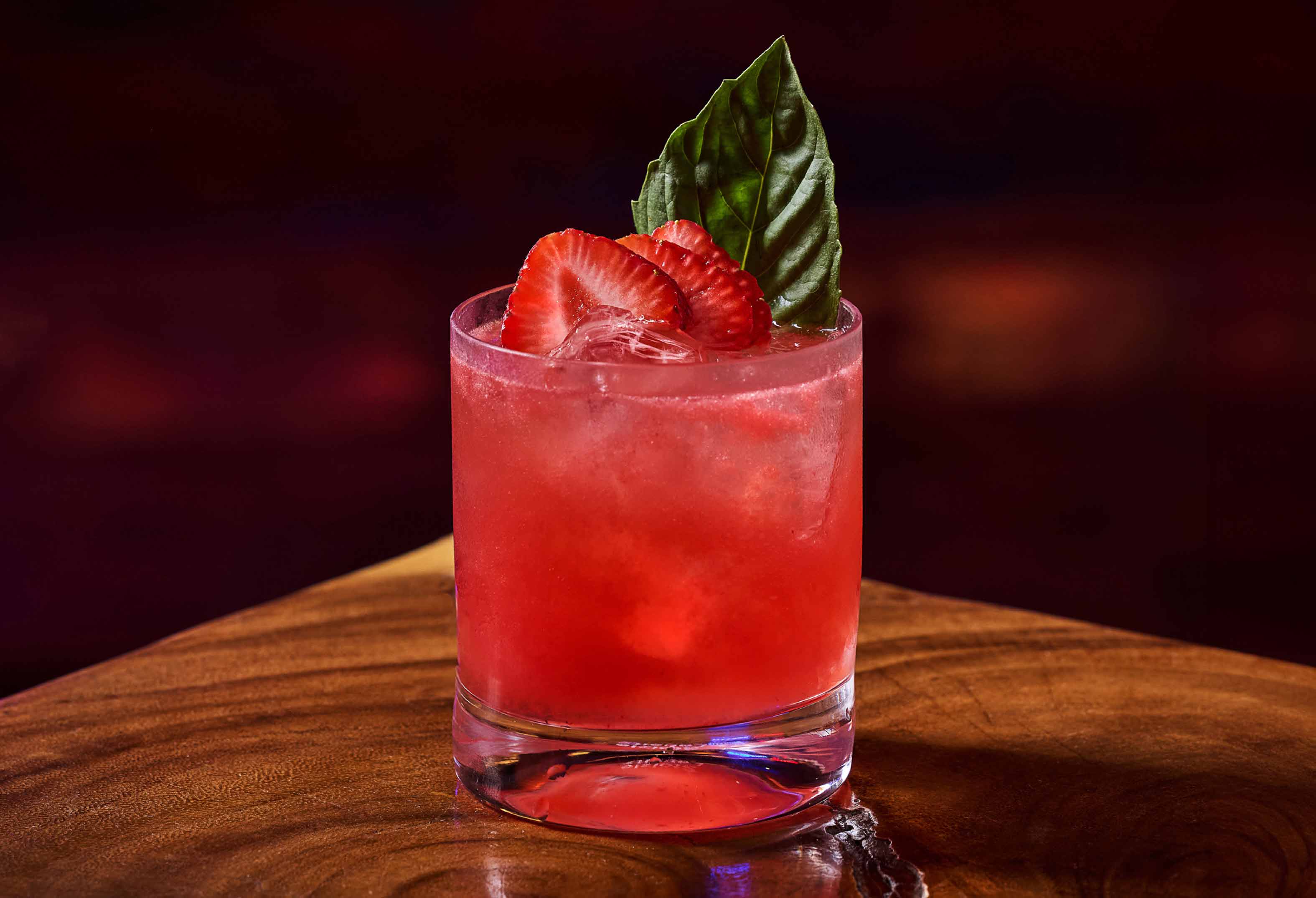 Red cocktail with strawberry and garnish at L Bar at Seminole Hard Rock Hollywood