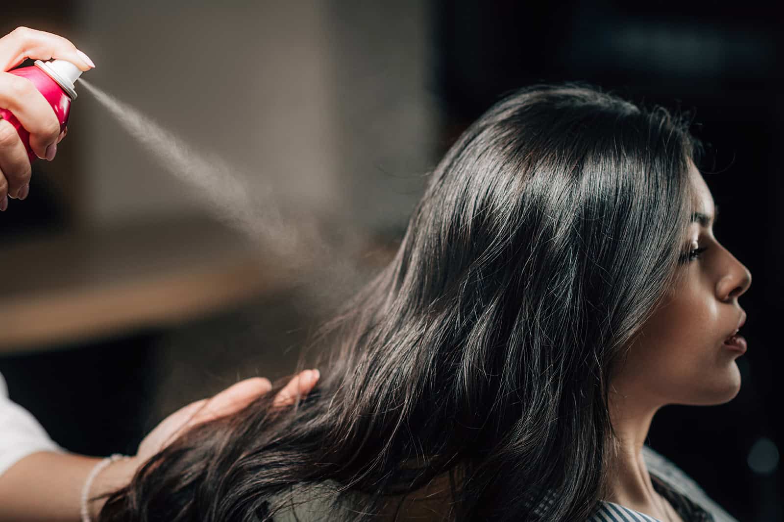 a woman spraying her hair