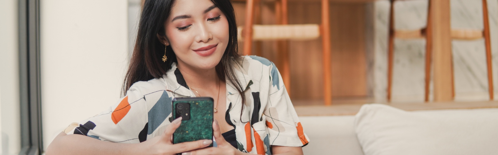 a woman sitting on a couch holding a phone