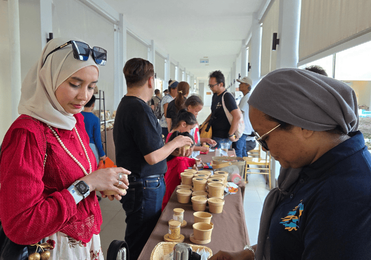 a group of people standing around a table with food items