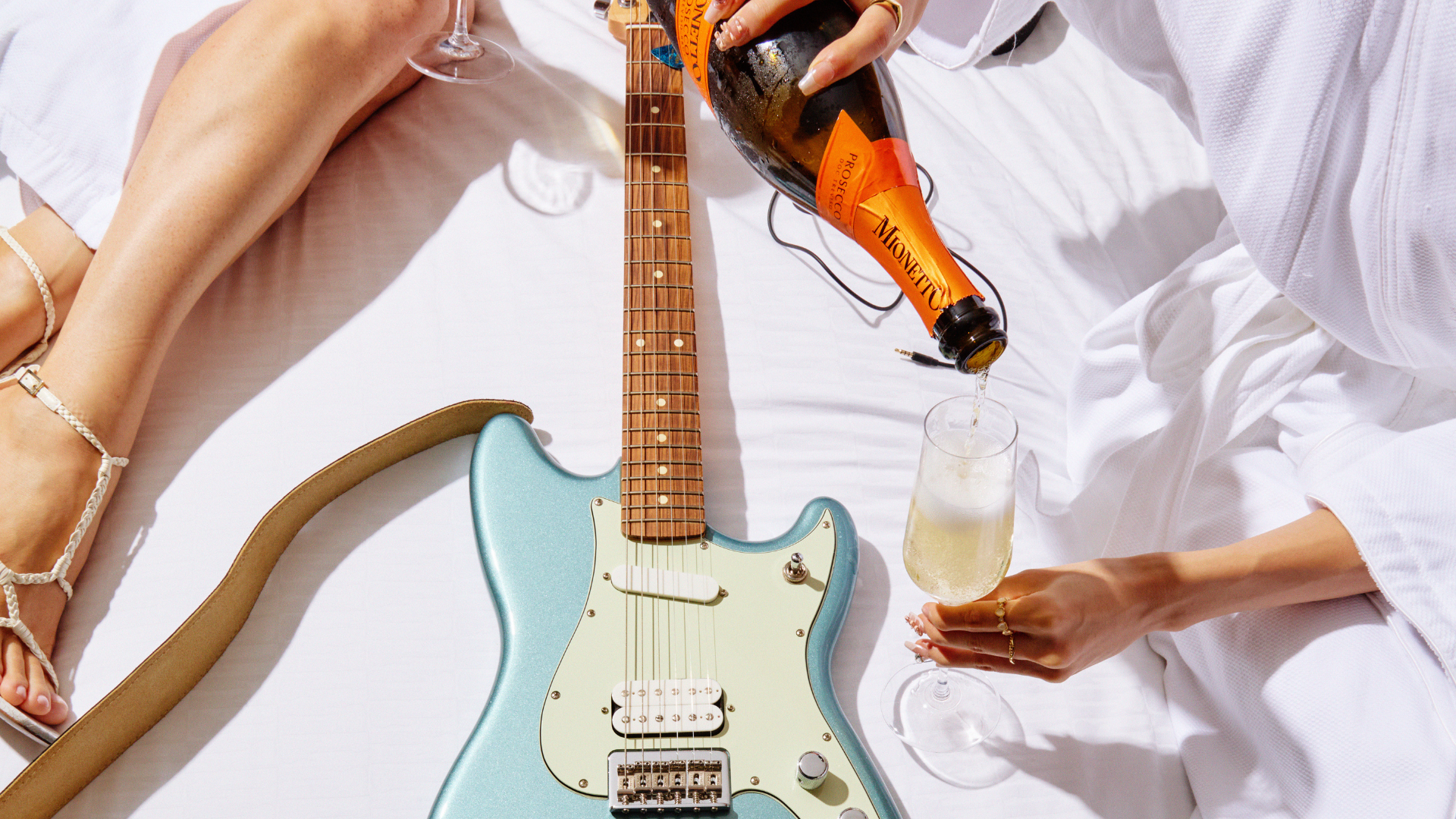 Two women on a bed with a guitar